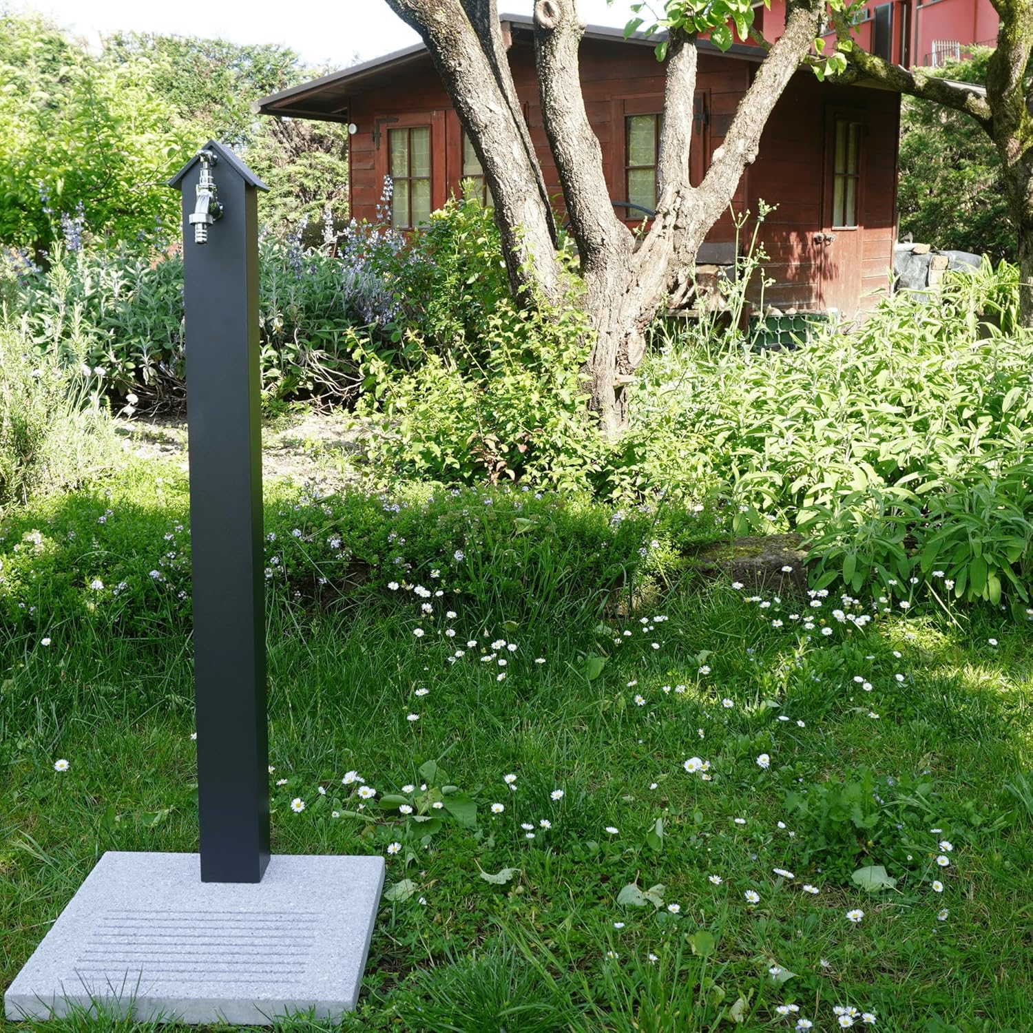 Fontana Emilia in giardino con rose e prato verde.